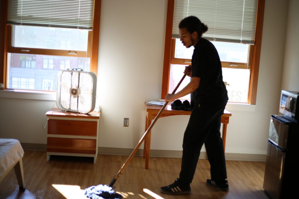 Christian cleans the floor of his room at Blanchet House.