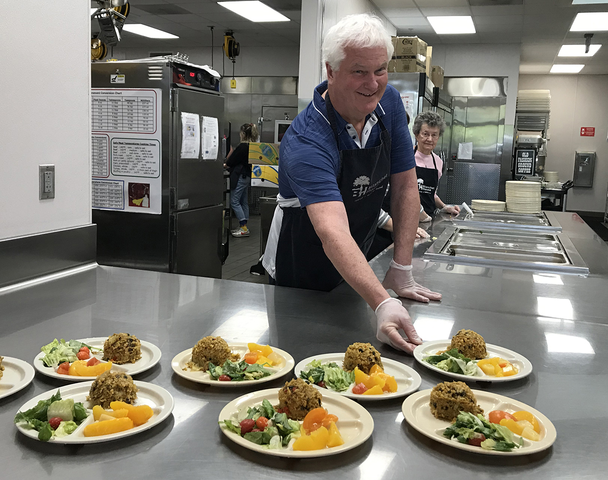 Ed O'Hanlon serving plates at Blanchet House in 2019.