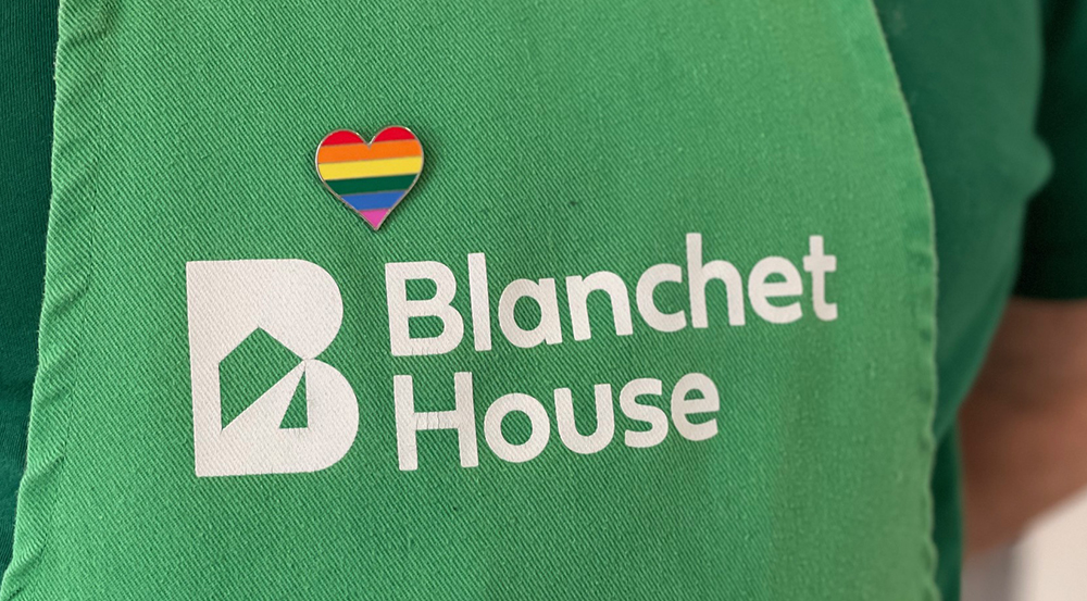 Pride pin on Blanchet House apron events