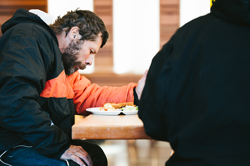 Homeless man eating at Blanchet House