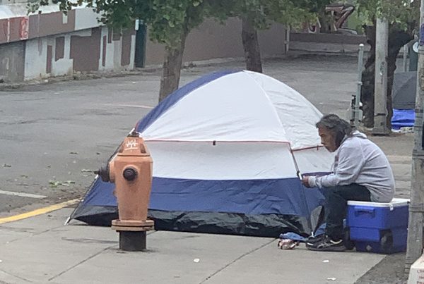 homeless man next to tent in old town