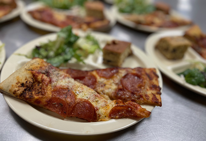 Pizza slices rescued from local pizzerias then reheated to serve for dinner help with food waste prevention.