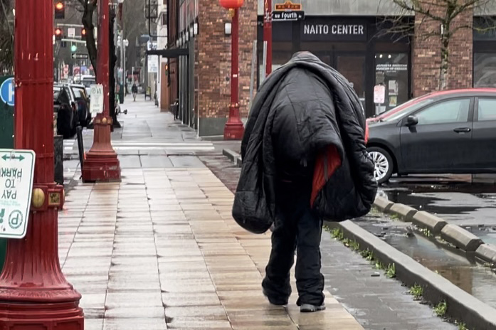 Homeless Man walking with sleeping bag