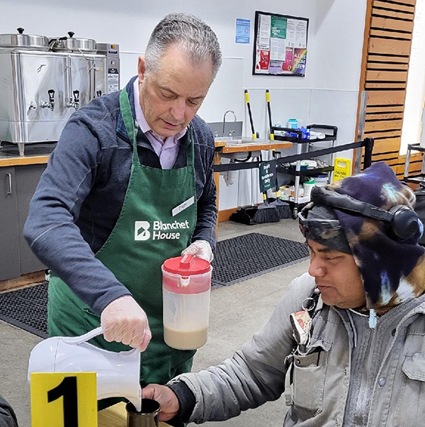 Dan Pippenger volunteers to serve coffee and milk to a guest in Blanchet House's cafe.