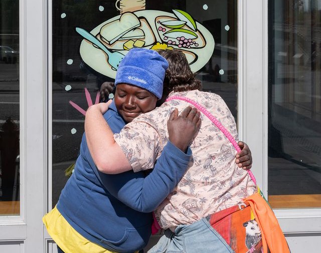 Duke Reiss hugs a guest outside Blanchet House