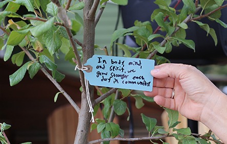 Pictured: Guests at Blanchet Farm's Grand Opening were asked to write messages of encouragement to hang on a plum tree that will be planted near the new facility.