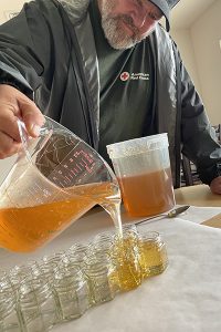 Blanchet Farm resident jarring honey from beekeeping program