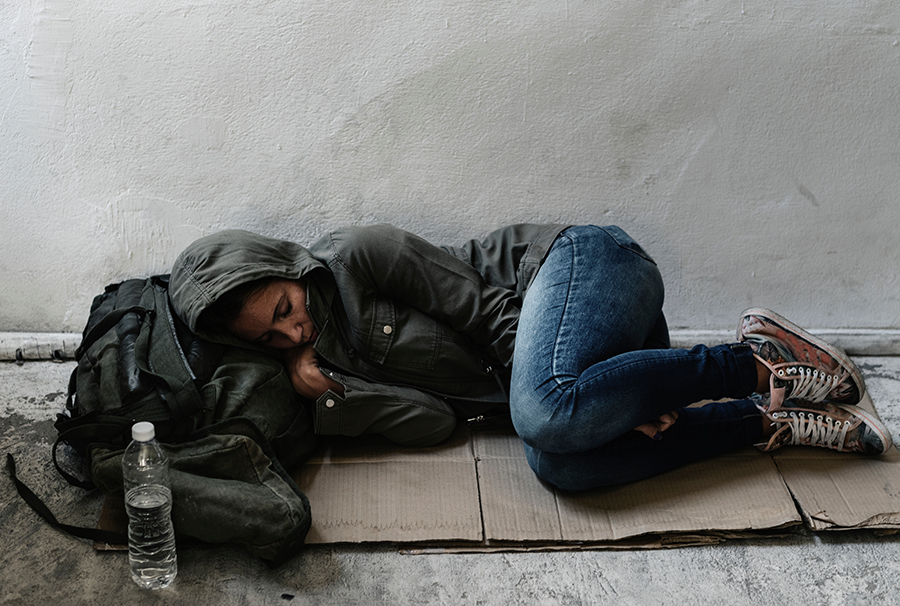 Homeless women sleep on ground