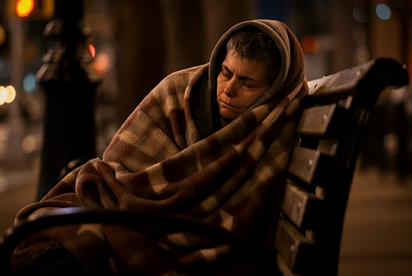 Homeless woman sleeping on bench