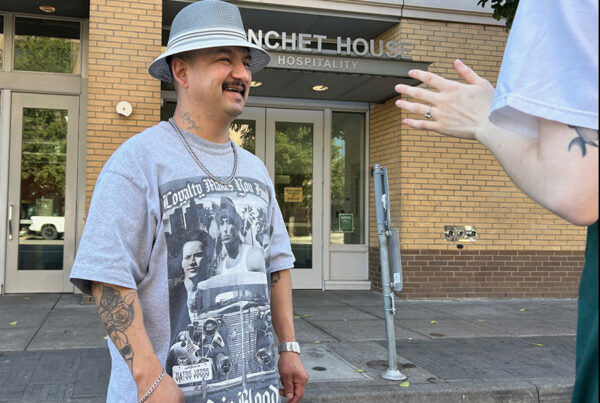 Peer support specialist Erik Ramirez talks with a homeless person in Blanchet House's cafe.