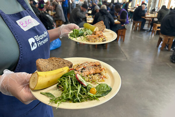 SNAP Cuts Volunteer holding plates salmons
