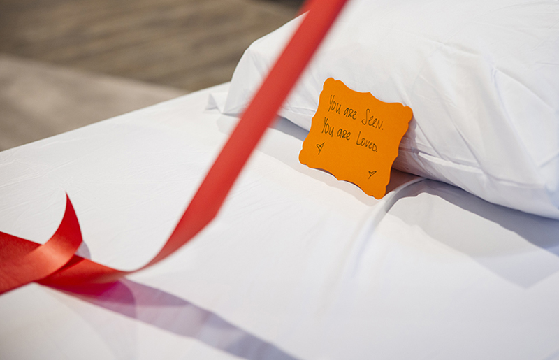 A note on a pillow, written by a supporter, reads, “You are seen. You are loved.”