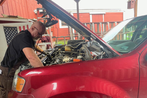 workforce training for recovery man works on engine at Blanchet Farm